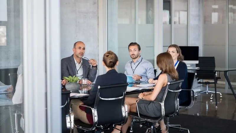 Des professionnels discutent autour d’une table de réunion