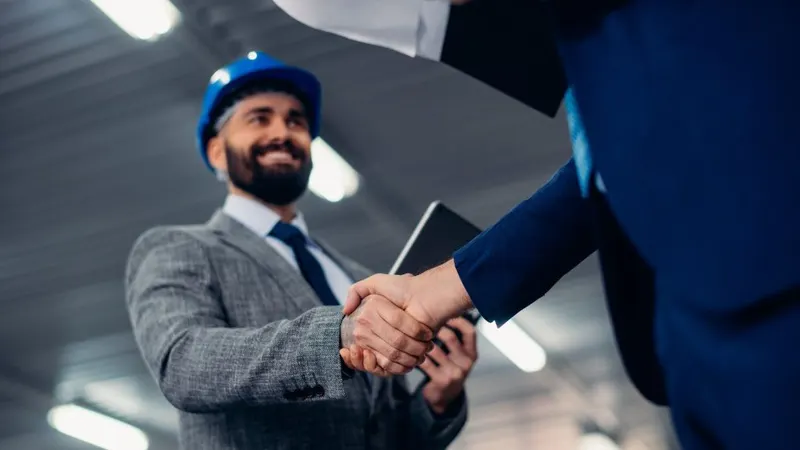 Une poignée de main entre un travailleur casqué et un partenaire