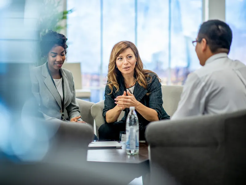Trois professionnels discutent autour d’une table basse
